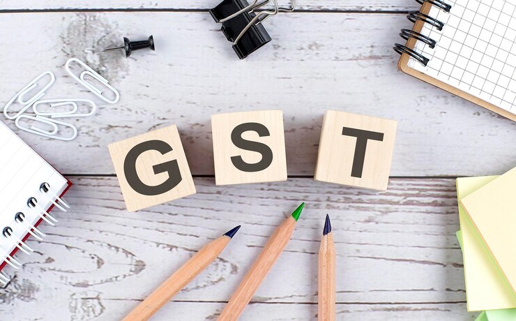 gst-text-wooden-block-with-office-tools-wooden-background_376538-1153