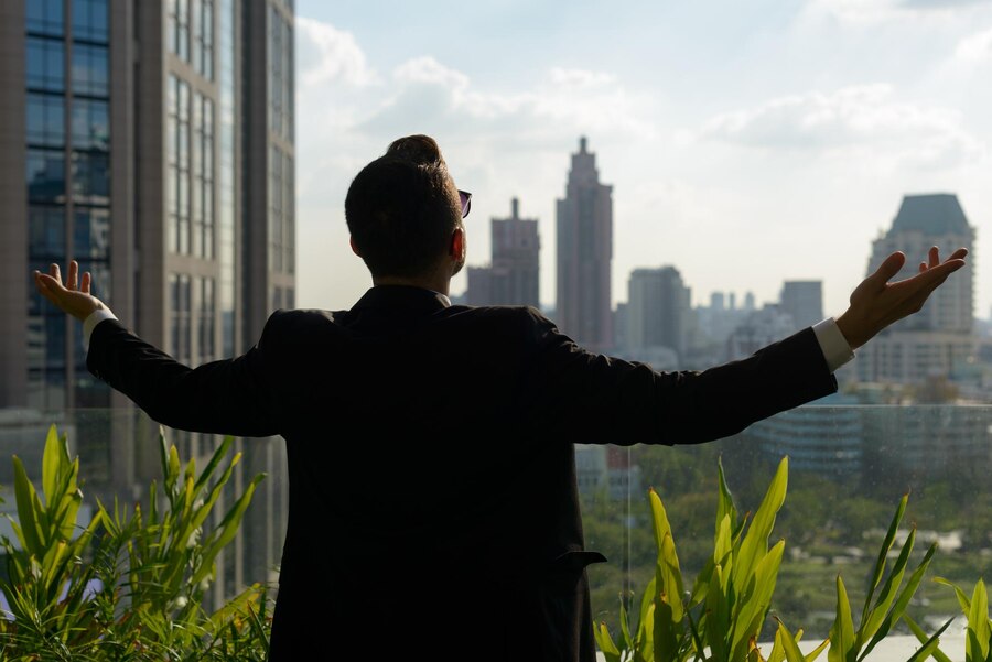 rear-view-man-standing-by-buildings-city-against-sky_1048944-28567645